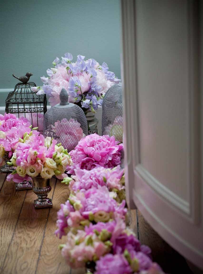 De petits vases fleuris de roses et de pivoines prêts à être disposés