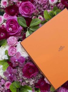 Un arrangement floral dans des tons roses avec article de luxe