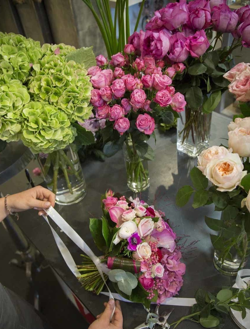 Une fleuriste préparant un bouquet dans notre magasin