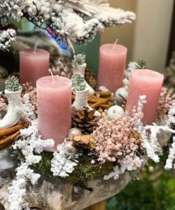 Une couronne de Noël avec des bougies roses