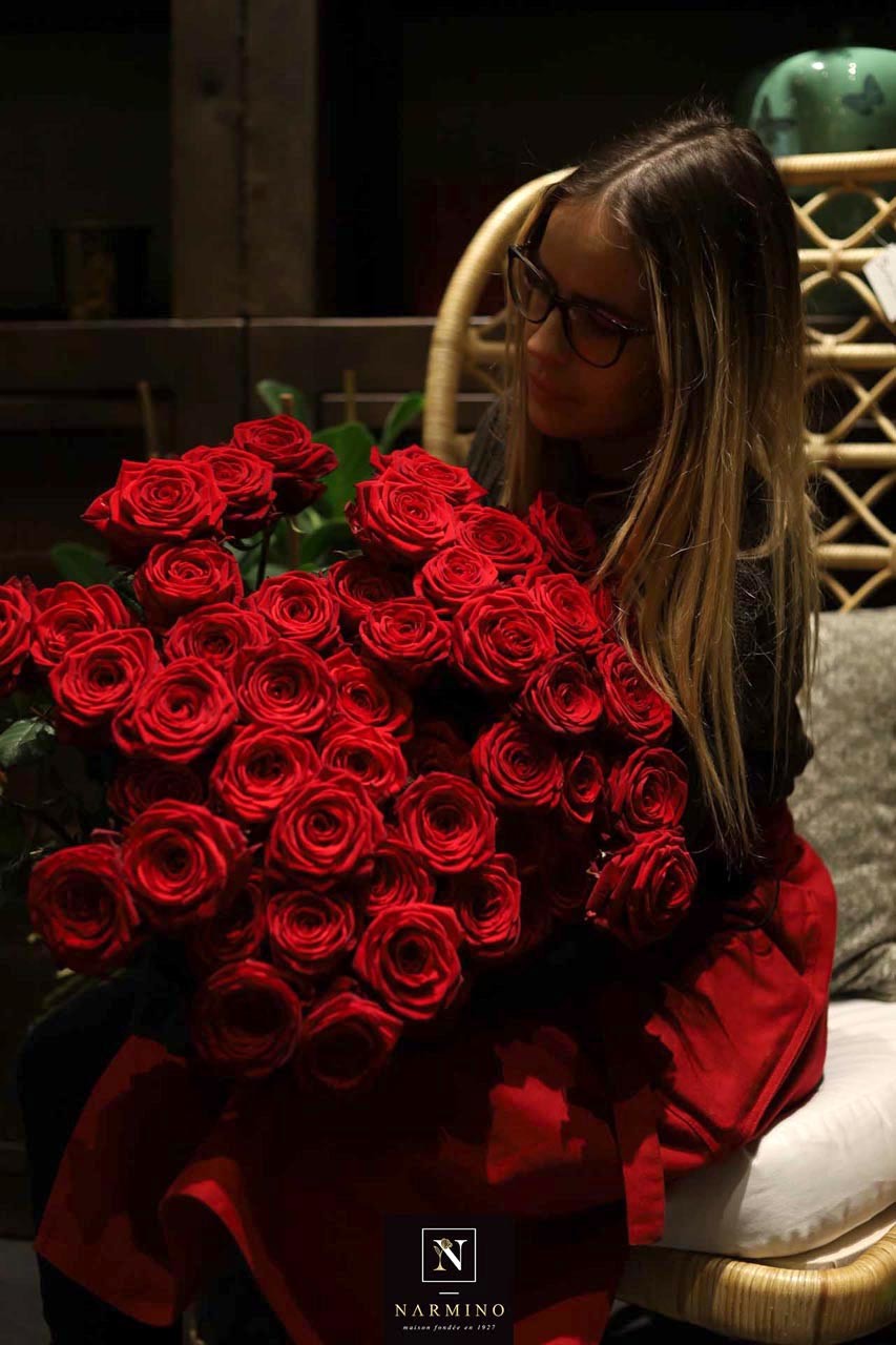 Une fleuriste préparant un bouquet de roses rouges