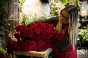 Fleuriste préparant un bouquet de roses rouges