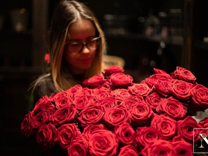 Fleuriste préparant un bouquet de roses rouges