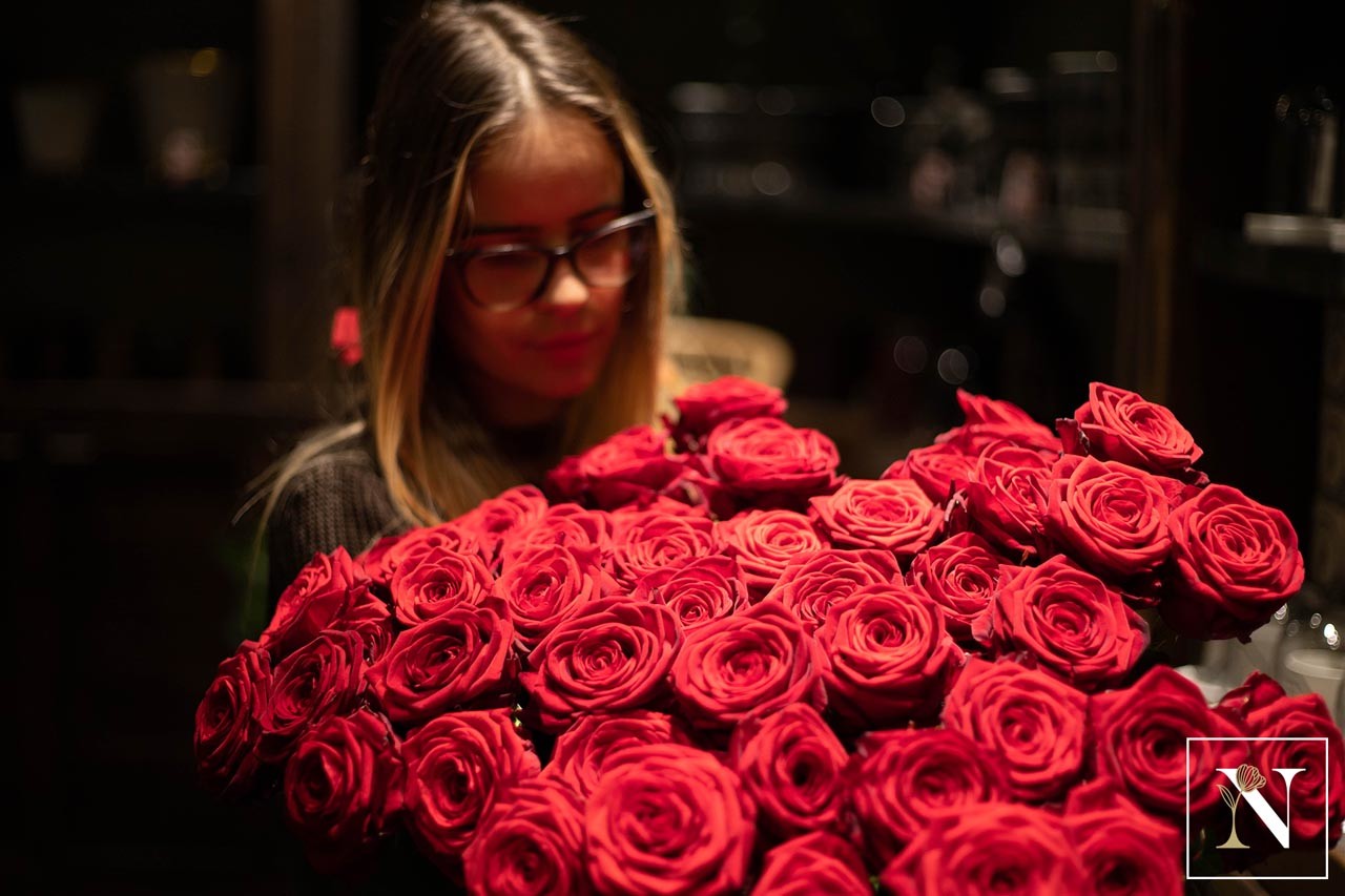 Fleuriste préparant un bouquet de roses rouges