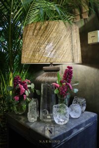 Une lampe à la lumière tamisée et son petit bouquet de fleurs