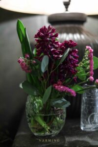 Une lampe à la lumière tamisée et son petit bouquet de fleurs