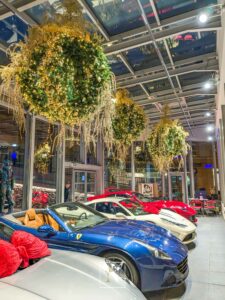 Décorations de Noël Narmino sous forme de luminaires scintillants, parmi de magnifiques véhicules haut de gamme, installés chez DPM Motors à Monaco.