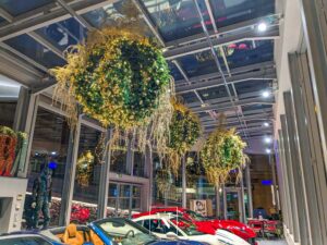Décorations de Noël Narmino sous forme de luminaires scintillants, parmi de magnifiques véhicules haut de gamme, installés chez DPM Motors à Monaco.