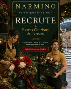 Two florists in brown uniforms pose with festive bouquets beside a dark green storefront sign that reads 'NARMINO Recrute Extras fleuristes & livreurs' for Christmas hiring.